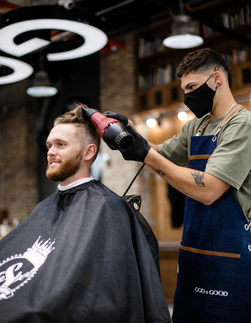 man in green and black crew neck t-shirt holding black dslr camera